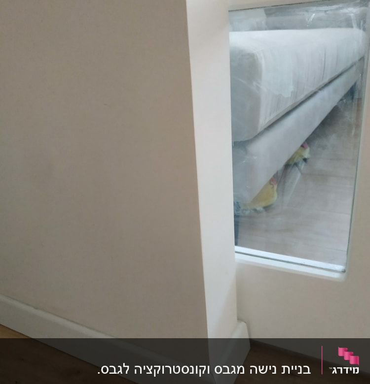 קיר גבס עם חלון זכוכית ודלת עץ